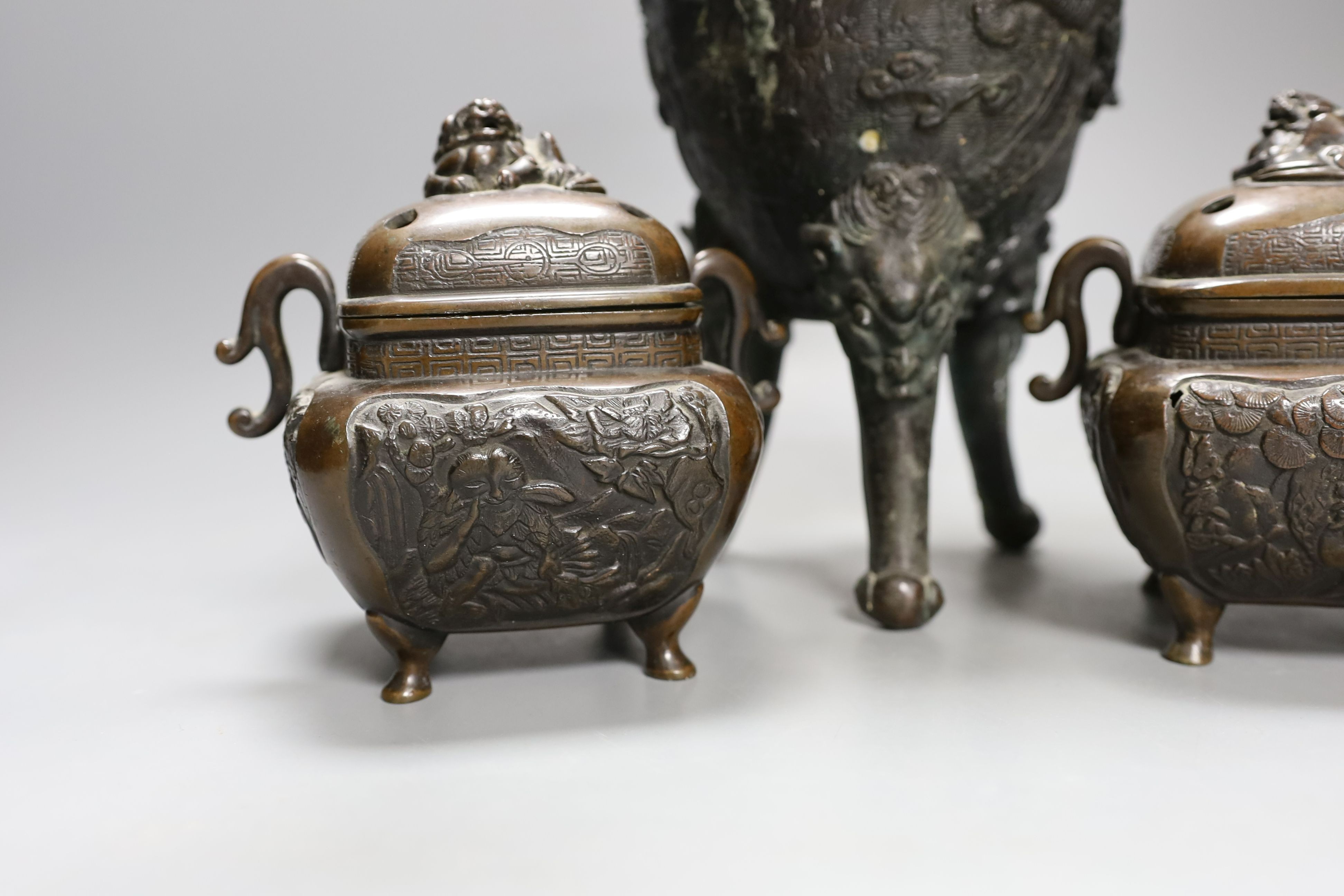 A pair of Japanese bronze censers and covers and a Japanese bronze tripod censer, 23cm tall, (3)